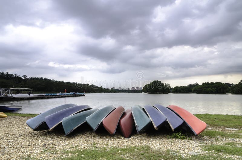 Group of colourful kayaks on the shore of lake stock photos Group of colourful kayaks on the shore of lake stock photos