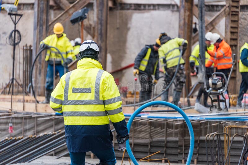 A Group of Construction Workers during Concrete Casting Work Using