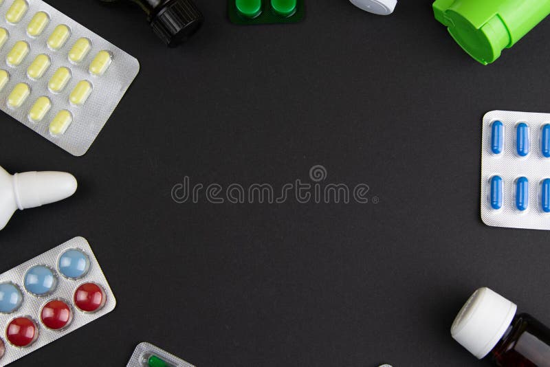 Group of different pills arranged in shape of circle on black background stock image