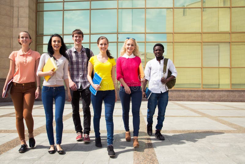 Group of diverse students walking together stock images