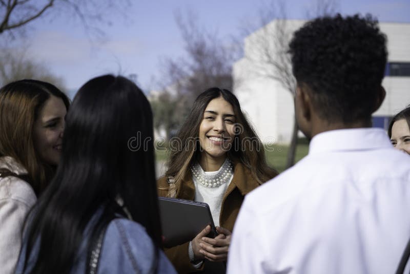 Group of diverse university students having a discussion outdoors on campus, sharing ideas and collaborating stock photos