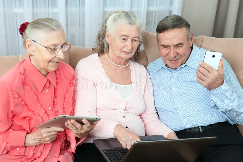 Group of elderly people. Group of older people having fun in communicating with the family on the internet in the comfortable living room. Concept an active life in retirement