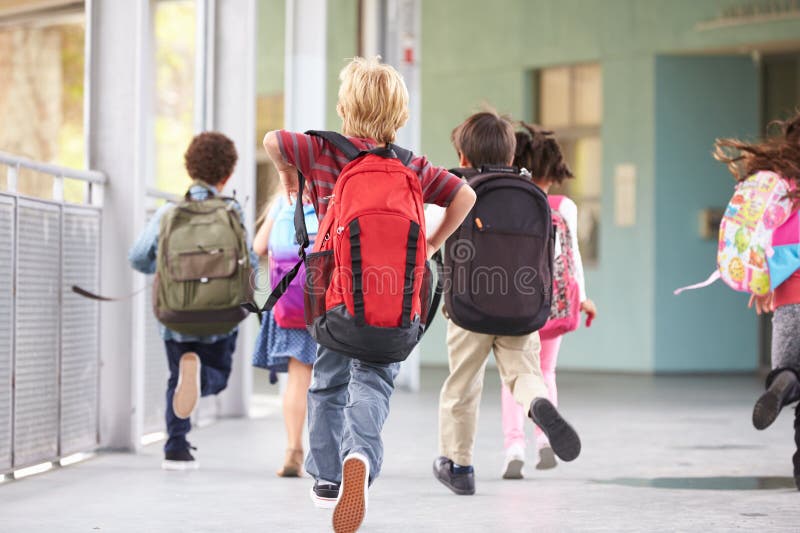 Group of elementary school kids running at school, back view royalty free stock photography