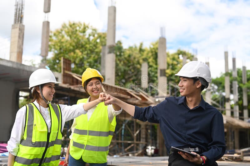 Group of Engineer in Protective Uniform Fist Bumping Hand after
