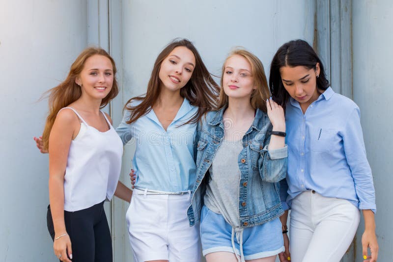 Group of female students in summer clothes posing together outdoor and looking at camera. Fashion portrait of young student stock photos Group of female students in summer clothes posing together outdoor and looking at camera. Fashion portrait of young student stock photos