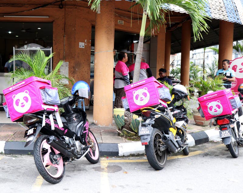 A group of Foodpanda riders chilling out at a restaurant in Ipoh, Malaysia. Their motorbikes are parked by the side of the road just outside the restaurant. A group of Foodpanda riders chilling out at a restaurant in Ipoh, Malaysia. Their motorbikes are parked by the side of the road just outside the restaurant