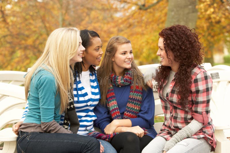 Group Of Four Teenage Girls Sitting And Chatting