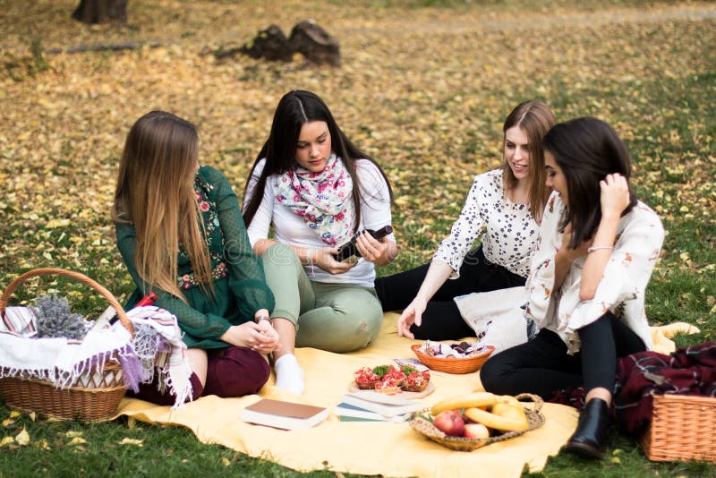 Group of young women having a fun picnic in the park