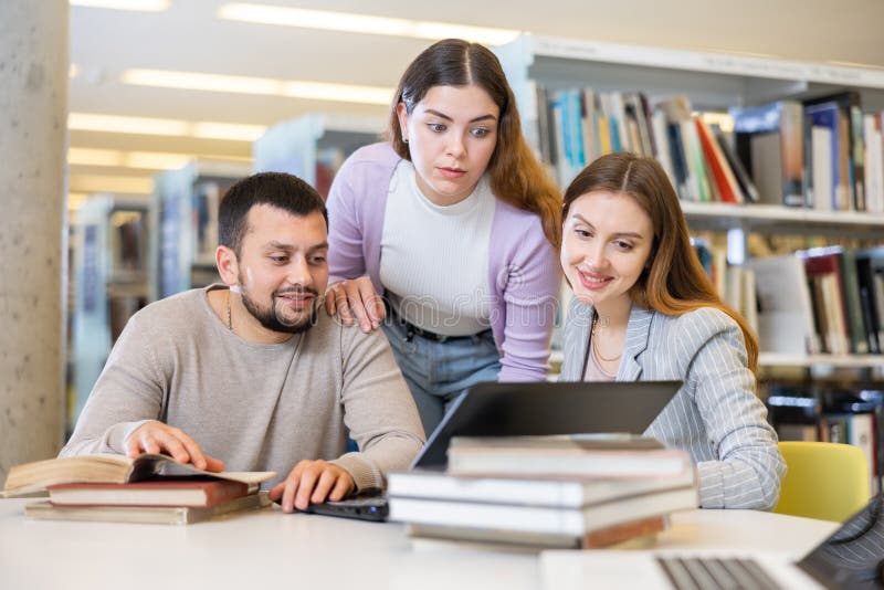Group Of Friendly Students Working On Joint Research In Library Stock group-of-friendly-students-working-on-joint-research-in-library-stock