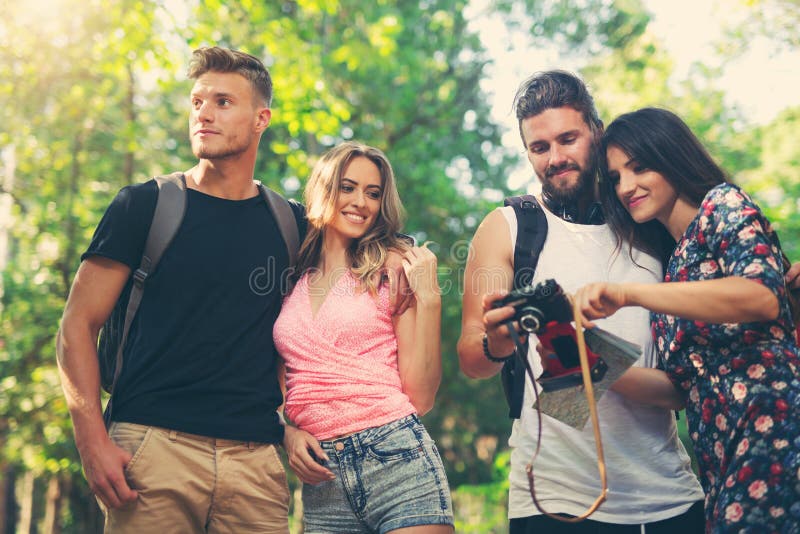 Group of friends or couples having fun with photo camera stock photo Group of friends or couples having fun with photo camera stock photo