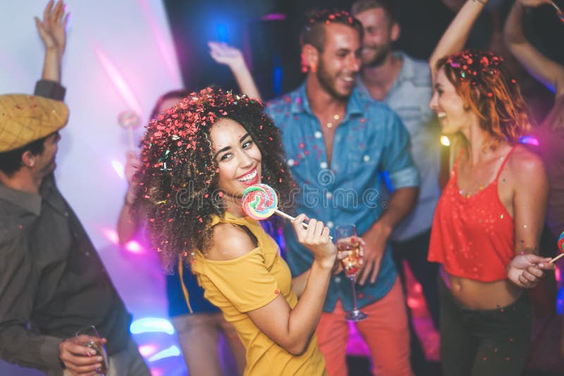 Group of friends dancing and drinking champagne at nightclub - Young happy people having fun and enjoying party eating candy royalty free stock photos Group of friends dancing and drinking champagne at nightclub - Young happy people having fun and enjoying party eating candy royalty free stock photos