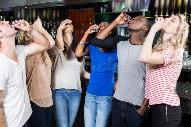 Group of friends drinking shots stock photo