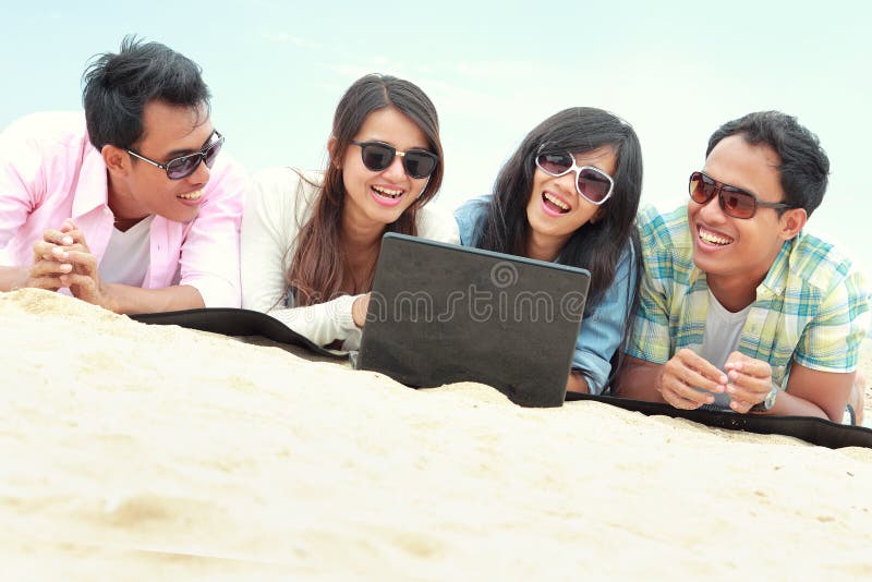Group Friends Enjoying Beach Holiday together with laptop royalty free stock photography Group Friends Enjoying Beach Holiday together with laptop royalty free stock photography