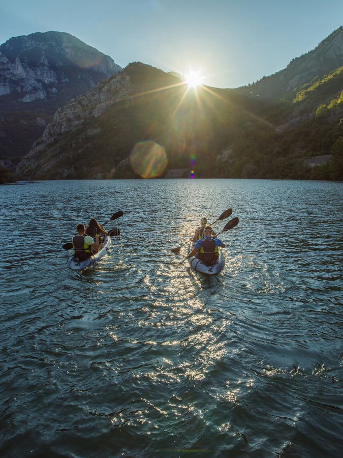 A group of friends enjoying fun and kayaking exploring the calm river, surrounding forest and large natural river stock images