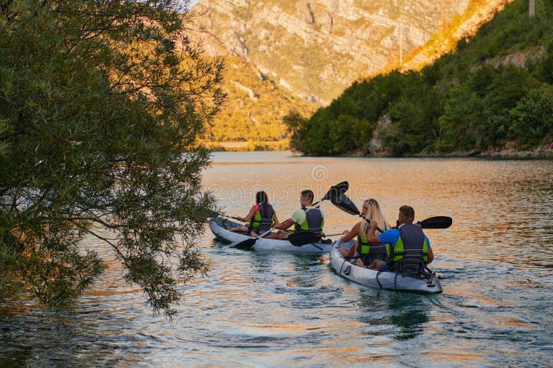 A group of friends enjoying having fun and kayaking while exploring the calm river, surrounding forest and large natural royalty free stock photography