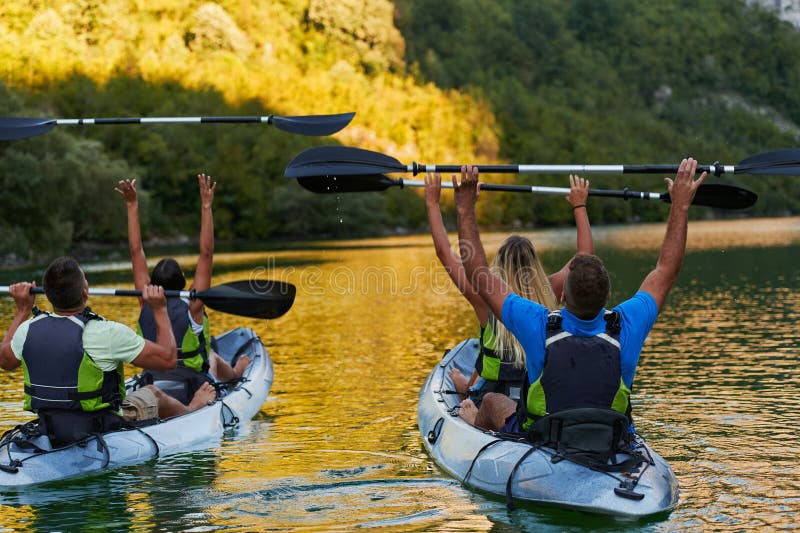 A group of friends enjoying having fun and kayaking while exploring the calm river, surrounding forest and large natural stock photos