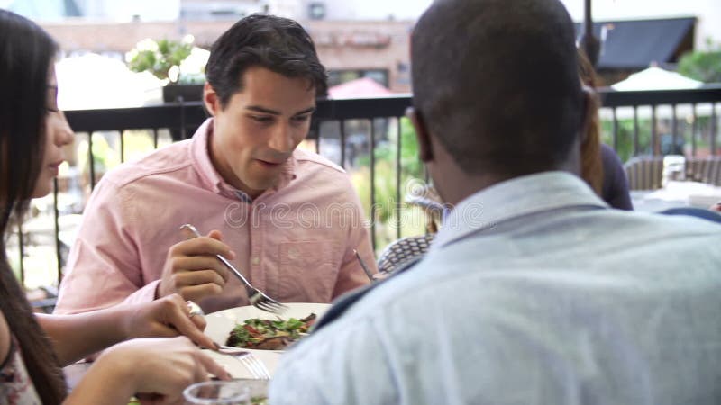 Group Of Friends Enjoying Meal At Outdoor Restaurant