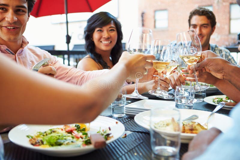 Group Of Friends Enjoying Meal At Outdoor Restaurant