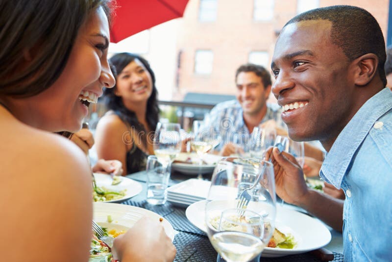 Group Of Friends Enjoying Meal At Outdoor Restaurant