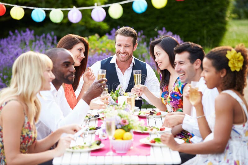 Gruppe Von Freunden Genießen Im Freien Dinner-Party, Sitzen Um Den Tisch Chatten.