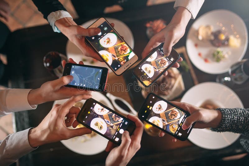 Group of friends going out and taking a photo of food together with mobile phone stock photography Group of friends going out and taking a photo of food together with mobile phone stock photography