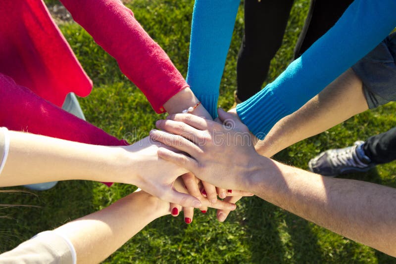 Group of friends pile up hands as unity oath royalty free stock image
