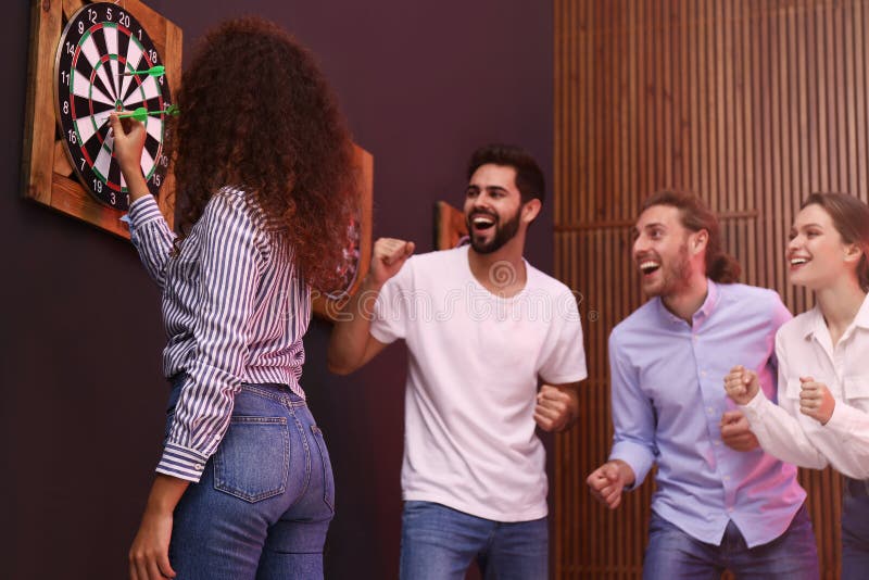 Group of friends playing darts royalty free stock images