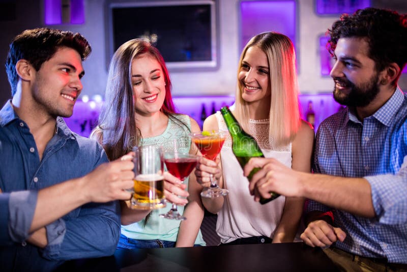 Group of friends toasting cocktail, beer bottle and beer glass at bar counter royalty free stock image Group of friends toasting cocktail, beer bottle and beer glass at bar counter royalty free stock image