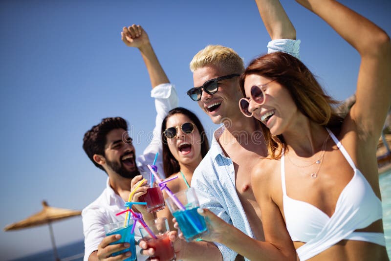 Group of friends having fun at summer party and drinking cocktail