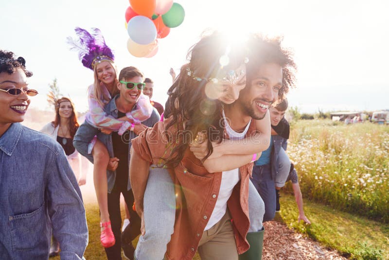 Group Of Friends Walking Back To Tent After Outdoor Music Festival With Balloons And Smoke Flare stock images Group Of Friends Walking Back To Tent After Outdoor Music Festival With Balloons And Smoke Flare stock images