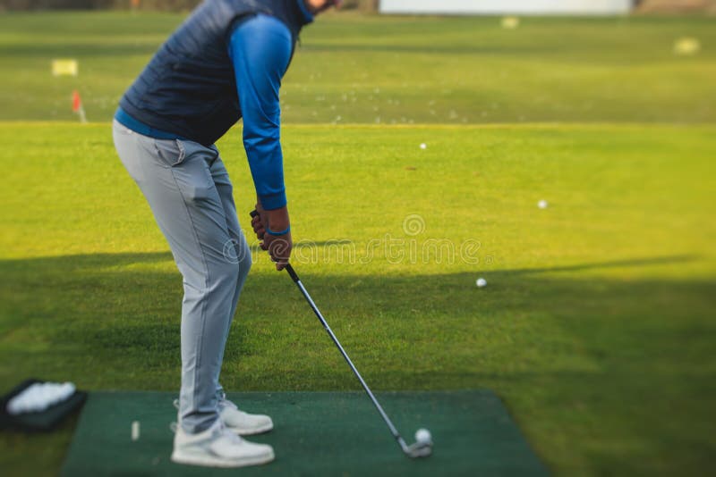 Group of Golfers Practicing and Training Golf Swing on Driving Range