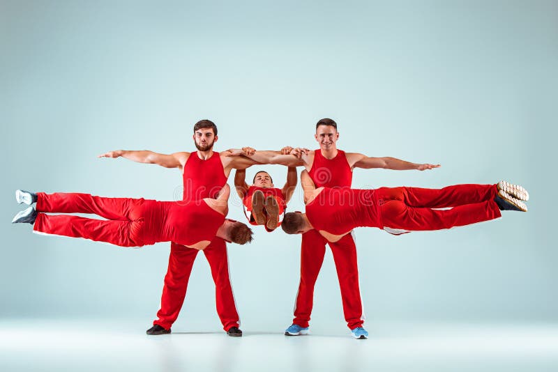 The Group Of Gymnastic Acrobatic Caucasian Men On Balance Pose Stock