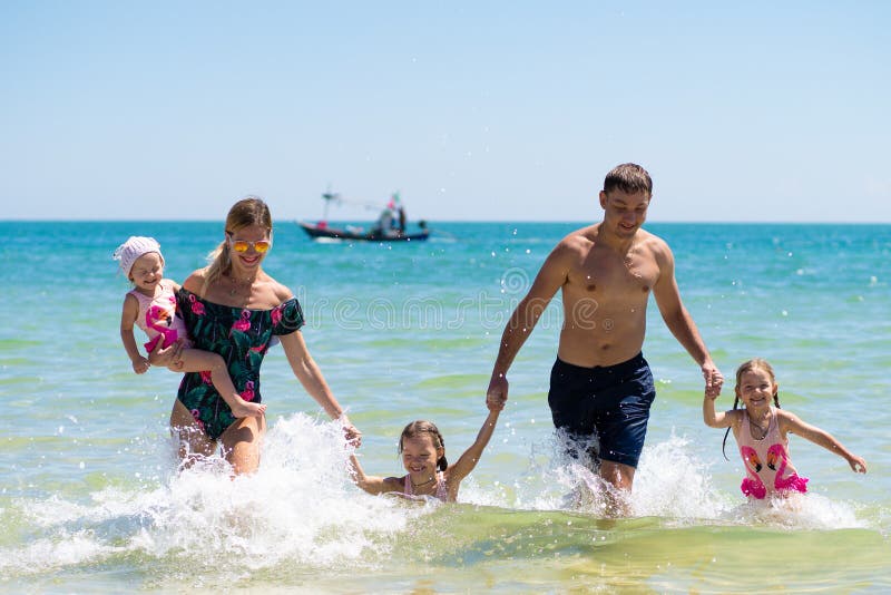 Group of happy children playing and splashing in the sea beach. Kids having fun outdoors. Summer vacation and healthy royalty free stock photography Group of happy children playing and splashing in the sea beach. Kids having fun outdoors. Summer vacation and healthy royalty free stock photography