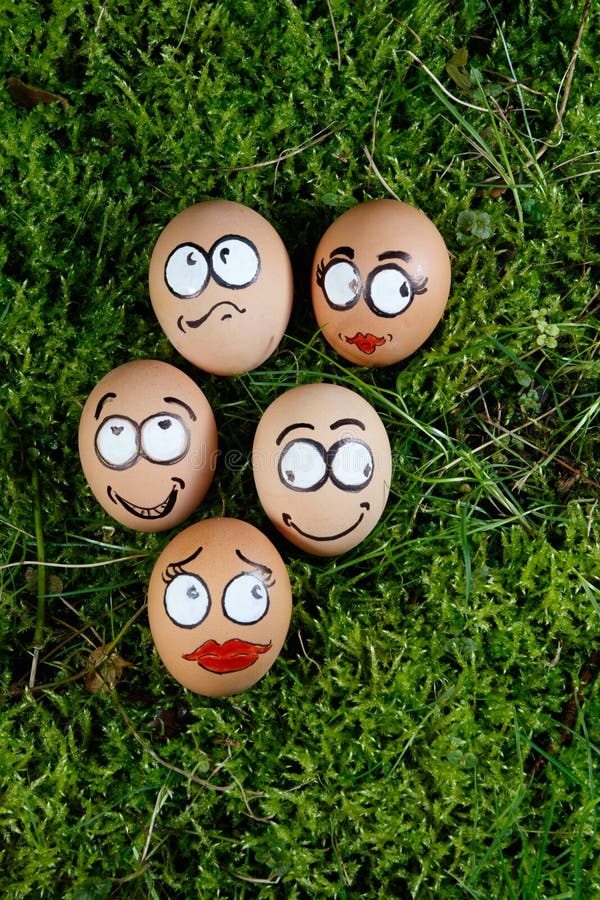 Group of happy face eggs on green grass