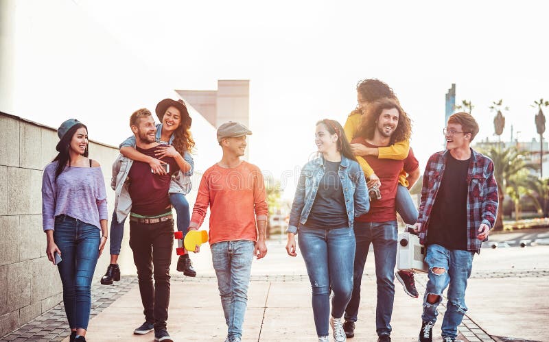 Group of happy friends having fun outdoor - Young people piggybacking while laughing and walking together in the city center