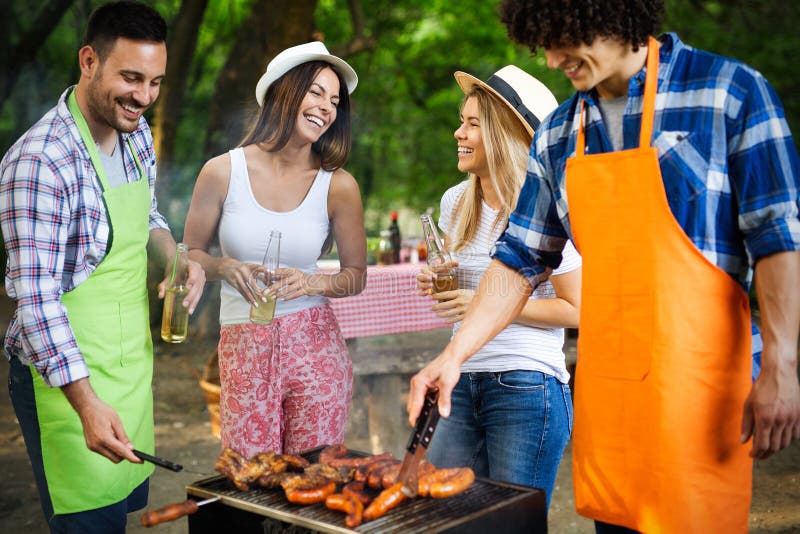 Group of Happy Friends Having Outdoor Barbecue Party and Fun Together