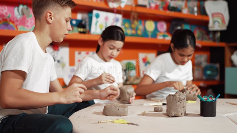 Group of happy smart diverse student working with clay at workshop. Edification stock video footage