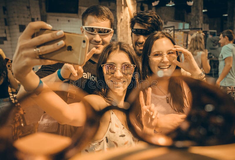 Group of happy and smiley young people making selfie inside sunglasses store stock photo Group of happy and smiley young people making selfie inside sunglasses store stock photo