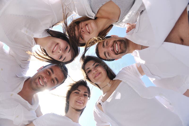 Group of happy young people in circle at beach