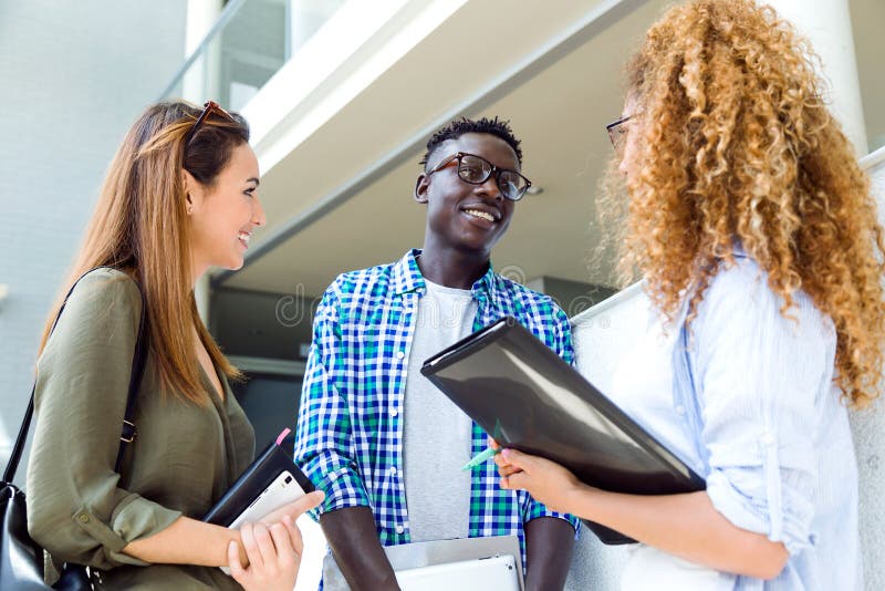 Group Of Happy Young Students Speaking In A University. Stock Photo