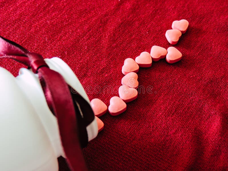 Group of hearts tablets with a white bottle on a red cloth background. Valentines day royalty free stock image Group of hearts tablets with a white bottle on a red cloth background. Valentines day royalty free stock image