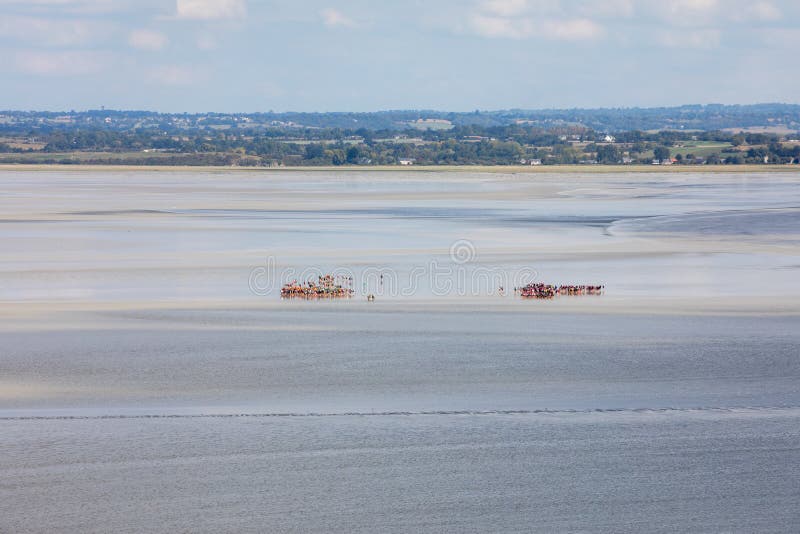 Group of Hikers in the Bay at Low Tide. Hike in the Bay with a