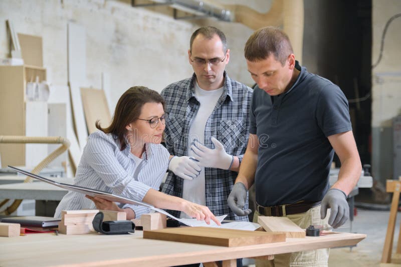 Group of industrial people client, designer or engineer and workers working together on project of wooden furniture stock photos Group of industrial people client, designer or engineer and workers working together on project of wooden furniture stock photos