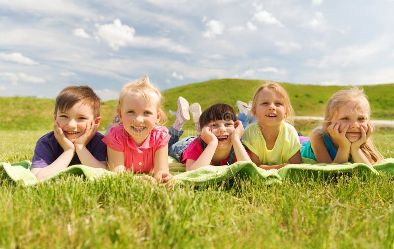 Group of kids lying on blanket or cover outdoors stock image Group of kids lying on blanket or cover outdoors stock image