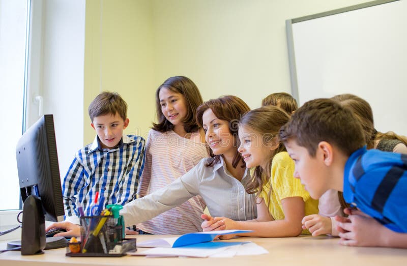 Group of kids with teacher and computer at school royalty free stock images