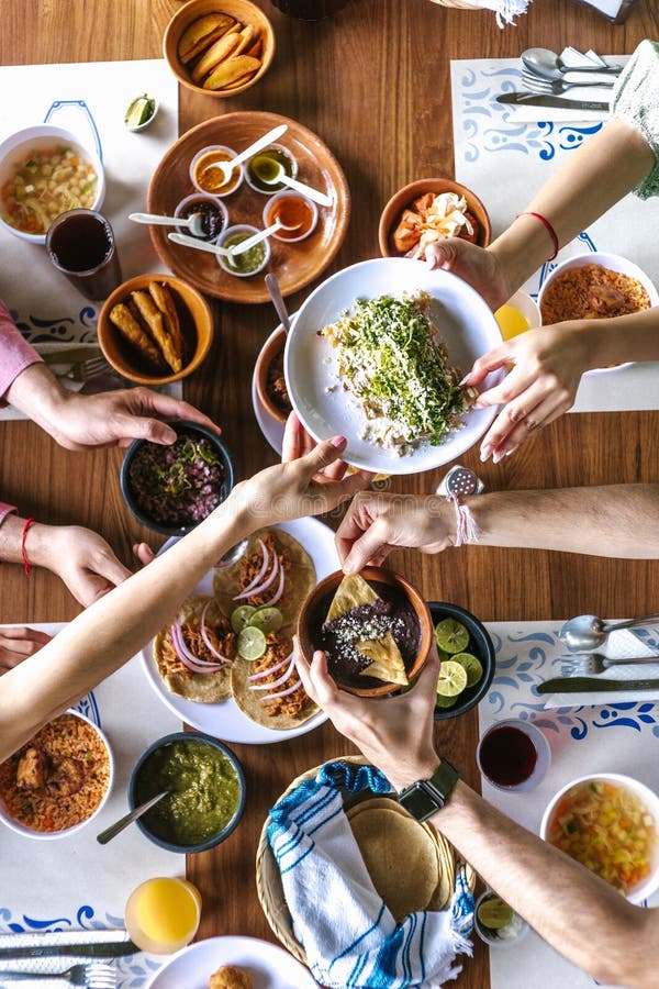 Group of Latin Friends Eating Mexican Tacos and Traditional Food