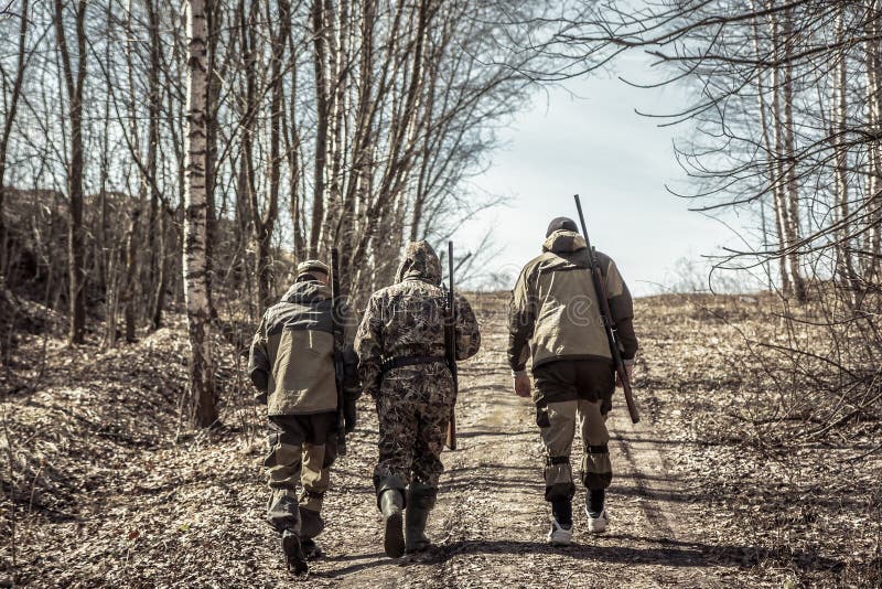 Group of men hunters going up on rural road during hunting season