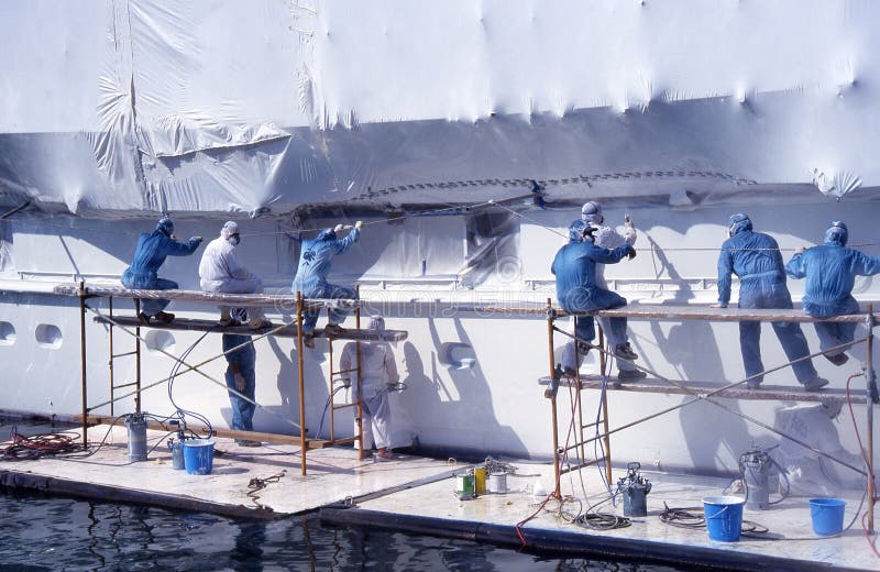 Group of Men in Overalls Painting Boat. Stock Photo Image of goggle