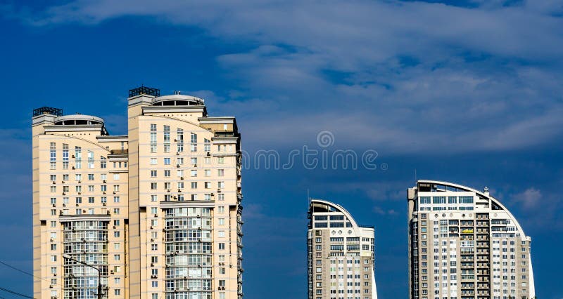 Group of modern multi-storey yellow and white big houses on background of blue sky