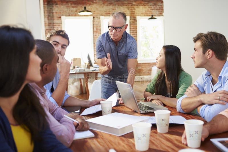 Group Of Office Workers Meeting To Discuss Ideas Stock